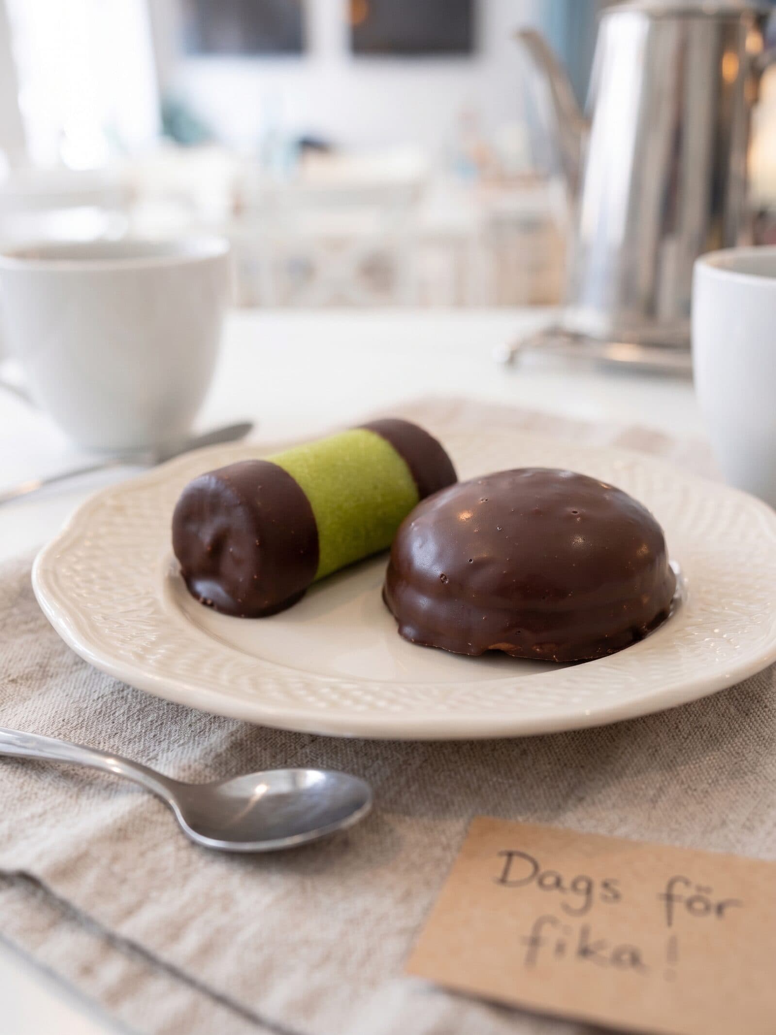 Hembakad punschrulle och chokladbiskvi på fat med kaffe