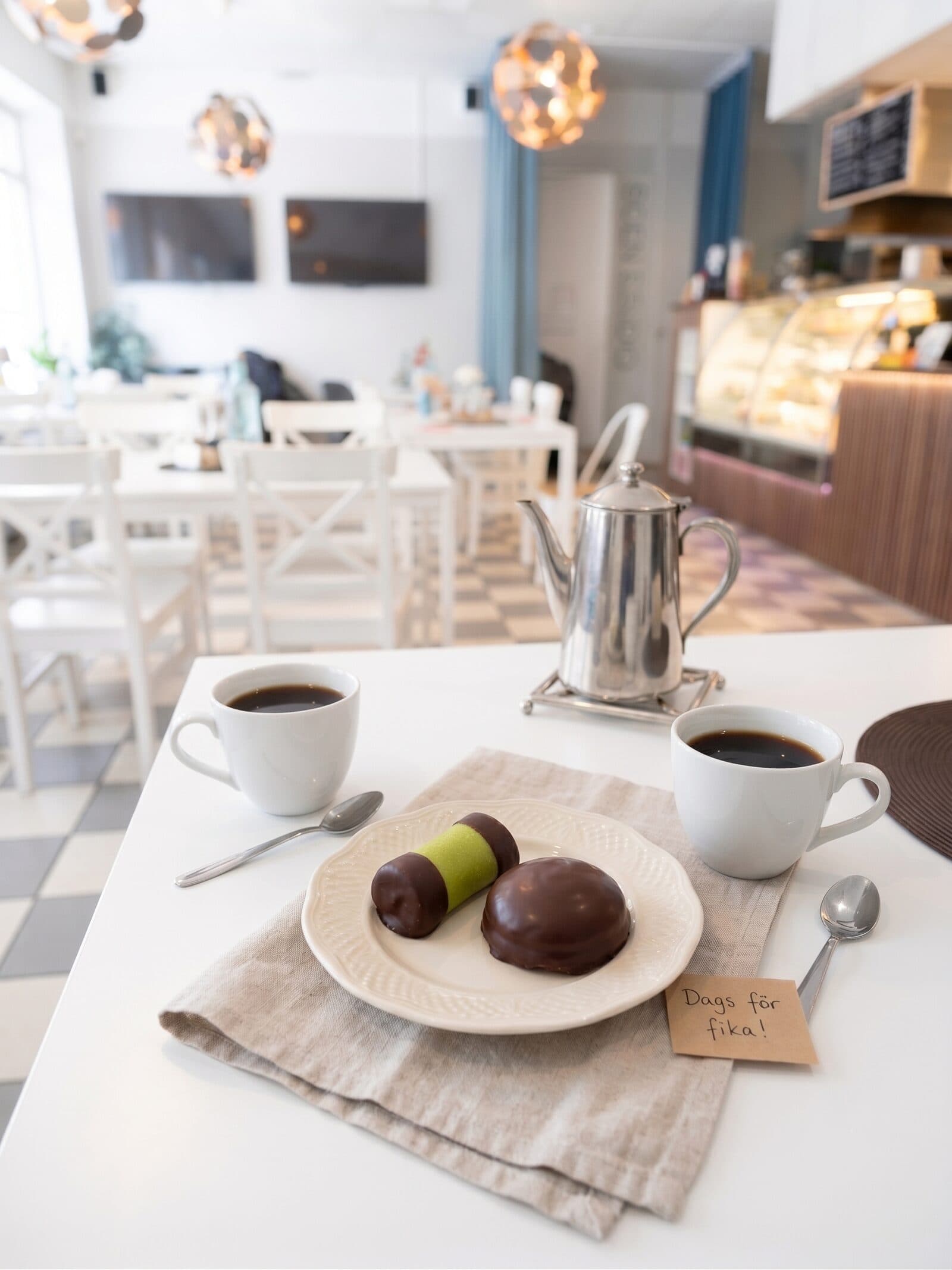 Fikabricka med kaffe, punschrulle och chokladbiskvi på Kafé Arte i Stockholm